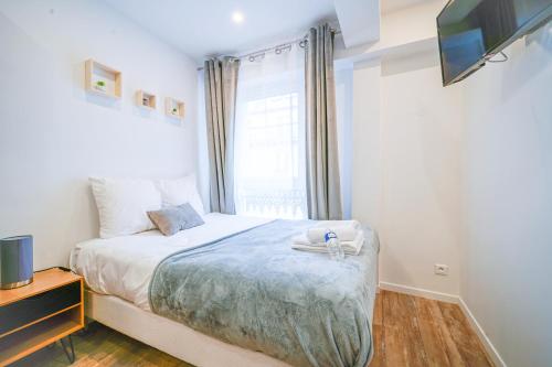 um pequeno quarto com uma cama e uma janela em Nets Inn Apartments - Saint Lazare em Paris