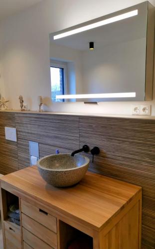 a bathroom with a bowl sink on a wooden counter at Neubauferienwohnung Ankerplatz in Stein