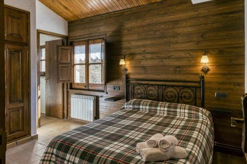 1 dormitorio con 1 cama con toallas en Nastura Casa Rural L'Art, en Rupit