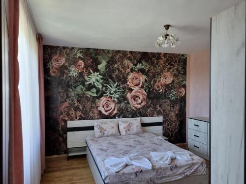 1 dormitorio con 1 cama con rosas en la pared en Villa Sunny Day, en Saints Constantine and Helena