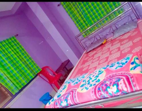 a toy room with a table and a pink umbrella at Barsha guest house in Bolpur