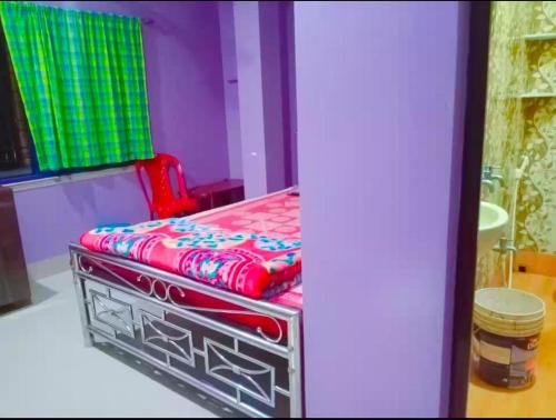 a bed in a room with a red bed sidx sidx sidx at Barsha guest house in Bolpur