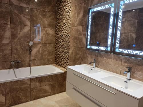 索維拉的住宿－Appartement golf Mogador，浴室设有2个水槽、浴缸和镜子