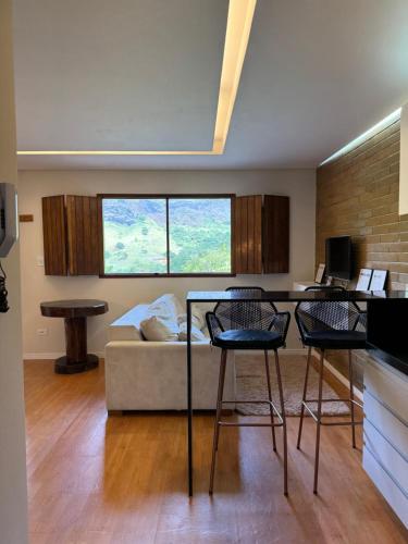 a living room with a couch and a table and chairs at EcoFlat Moderno e Aconchegante in Bonito