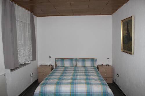 a bedroom with a bed with a plaid bedspread at W.I.L.A. in Helmbrechts
