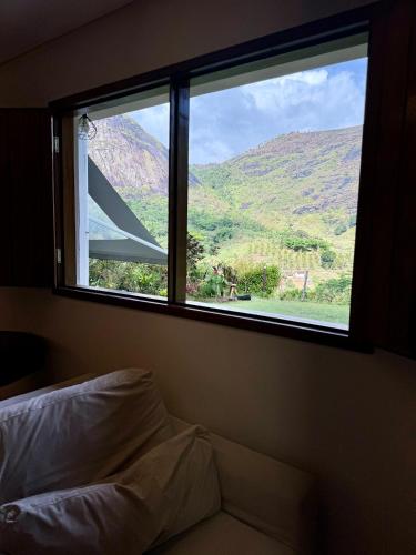 a bedroom with a window with a view of a mountain at EcoFlat Moderno e Aconchegante in Bonito