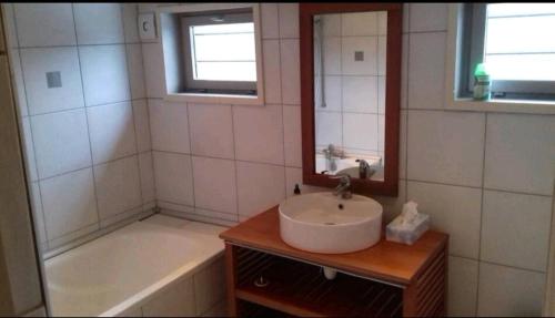 une salle de bain avec un lavabo et une baignoire dans l'établissement Maison campagne, à Locon