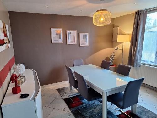 une salle à manger avec une table et des chaises blanches dans l'établissement Maison campagne, à Locon