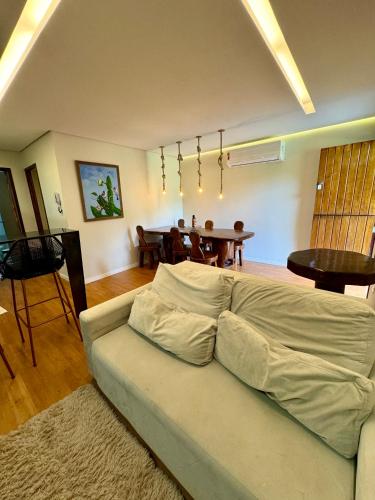 a living room with a couch and a table at EcoFlat Moderno e Aconchegante in Bonito