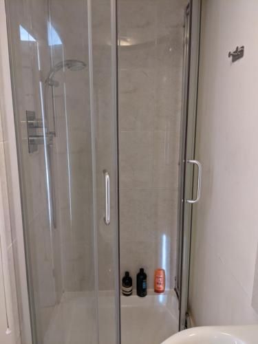 a shower with a glass door in a bathroom at Central and peaceful room with your own bathroom in London