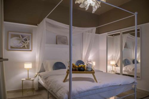 a bedroom with a canopy bed and a table with fruit on it at Chic & Cozy Apartment in Alexandroupoli