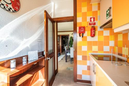 - une cuisine avec du carrelage jaune et orange sur le mur dans l'établissement Akisol Troia Retreat, à Tróia