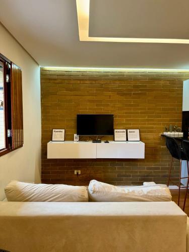a room with two beds and a tv on a wall at EcoFlat Moderno e Aconchegante in Bonito