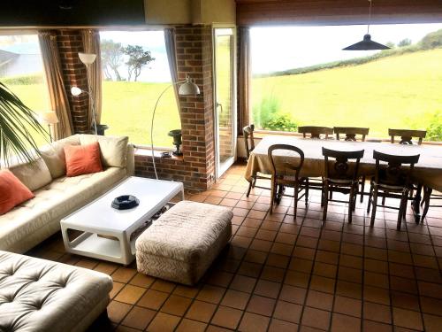 un salon avec un canapé, une table et des chaises dans l'établissement Green Beach, à Hautot-sur-Mer