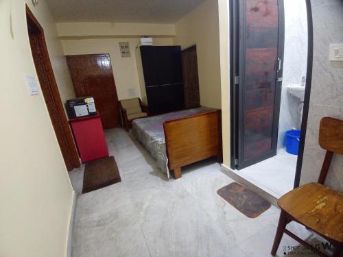 um quarto com um frigorífico e uma cama em The Tulip Touch for Couples. em Calcutá