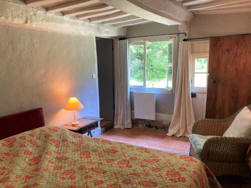 une chambre avec un lit, une chaise et une fenêtre dans l'établissement Maison de Noemie, à Varengeville-sur-Mer