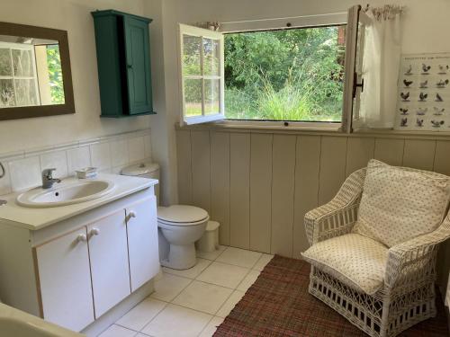 La salle de bains est pourvue d'un lavabo, de toilettes et d'une chaise. dans l'établissement Maison de Noemie, à Varengeville-sur-Mer
