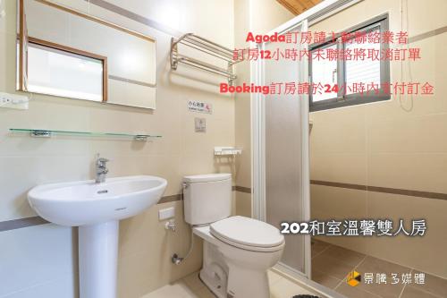 a bathroom with a white toilet and a sink at Harbour Enjoy Homestay in Yilan City