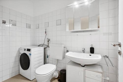 a white bathroom with a toilet and a sink at OH05 Apartment in Flughafennähe! in Mörfelden-Walldorf