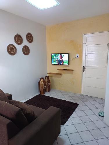 uma sala de estar com um sofá e uma televisão na parede em Apat 04 Próx a feira da Sulanca, Caruaru-PE em Caruaru