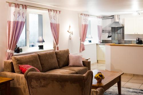 a living room with a couch and a kitchen at Heart of Polen appartements in Piechowice