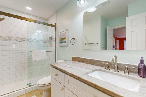 a bathroom with a sink and a toilet and a mirror at Oyster Pointe 807F in Sunset Beach