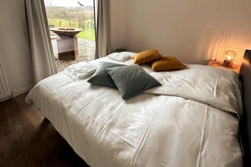 a white bed with pillows on it in a bedroom at Welkom in Vloesberg n°54 in Flobecq