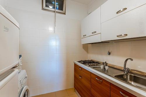 uma cozinha com um lavatório e um fogão em Appartamento Sanremo em Sanremo