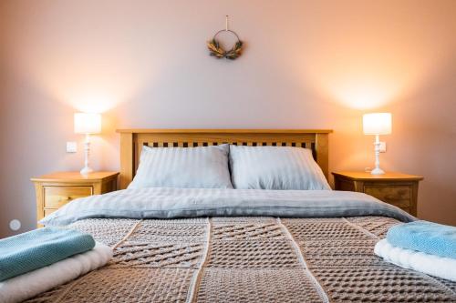 a bedroom with a bed with two lamps on two tables at Heart of Polen appartements in Piechowice