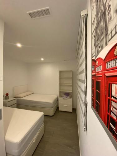 a small bedroom with two beds and a red telephone booth at Apartamentos Calanegra con Piscina y Solárium en Puerto de Mazarrón Costa Cálida in Murcia