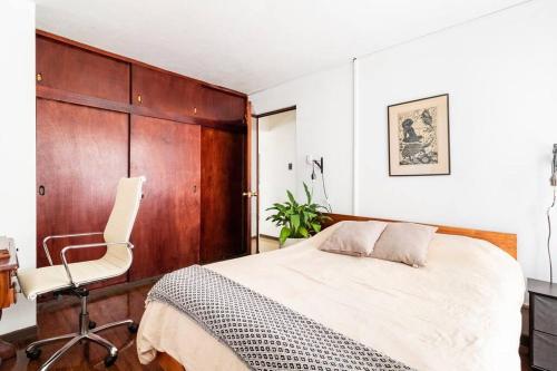 ein Schlafzimmer mit einem Bett und einem Stuhl darin in der Unterkunft Céntrica y Acogedora Casa in San Pedro