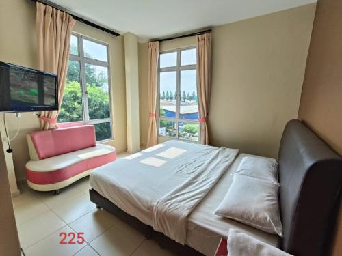 een slaapkamer met een bed, een bank en een televisie bij Doris Hotel in Melaka