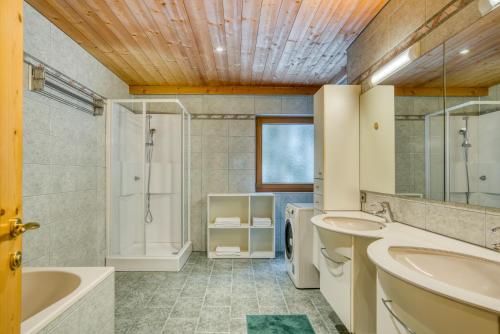 een badkamer met 2 wastafels, een bad en een douche bij Landhaus Moritz in Leutasch