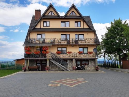 a large house with a balcony on a street at Willa Wyrostek in Bańska Wyżna