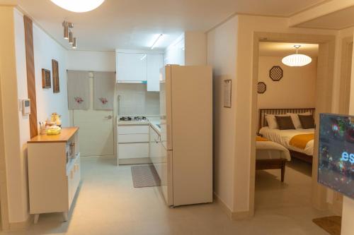 ein Zimmer mit einer Küche und ein Schlafzimmer mit einem Bett in der Unterkunft Soo Stay-4bed&Double Room, Hongdae, Sinchon 10min in Seoul