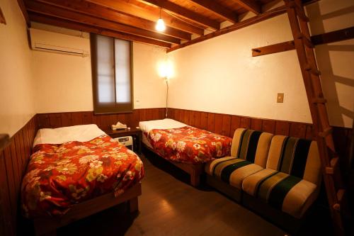Cette petite chambre comprend 2 lits et une fenêtre. dans l'établissement 白馬シェア 落倉店 Hakuba share-Ochikura, à Yotsuya