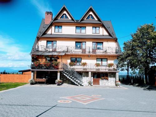 a large house with a balcony on the side of it at Willa Wyrostek in Bańska Wyżna