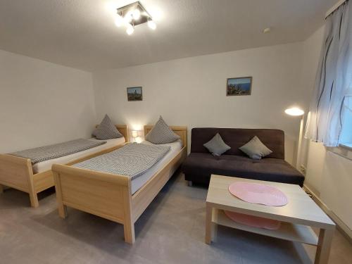 Habitación pequeña con 2 camas y sofá en Ferienwohnung Talgrund "Im Grünen", en Frammersbach