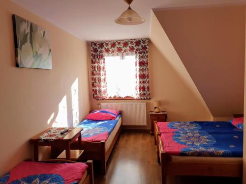 a small room with two beds and a window at Willa Wyrostek in Bańska Wyżna