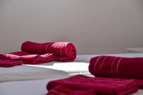 een stapel rode handdoeken zittend op een bed bij Ático en Mar de Nerja in Nerja