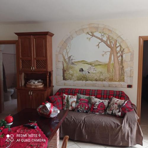una sala de estar con sofá y una pintura en la pared en Casa di Peppe o'Biond, en Procida