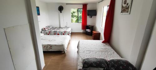 Habitación pequeña con 2 camas y ventana en Finca hotel los cocos, en Montenegro