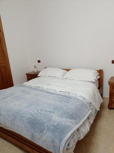 a bedroom with a bed with a blue blanket on it at Casa di Peppe o'Biond in Procida