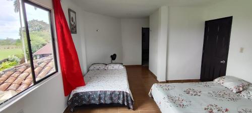Habitación con 2 camas y ventana en Finca hotel los cocos, en Montenegro
