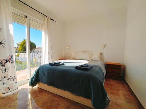 um quarto com uma cama e uma grande janela em Casa cipreses 6 nerja em Nerja