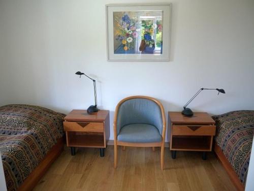 a bedroom with two beds and a chair and a desk at Ferienwohnung Axeli Knapp in Schleswig