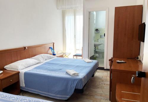 a bedroom with a blue bed and a bathroom at Hotel Caravan B&B in Pesaro