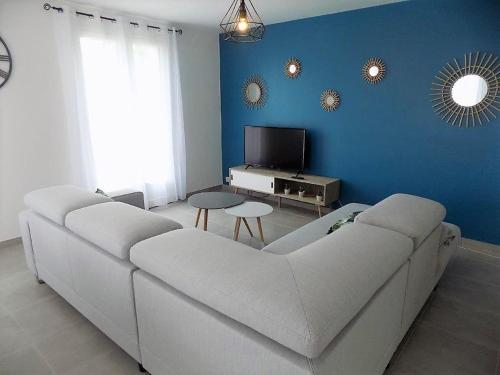 - un salon avec un canapé blanc et un mur bleu dans l'établissement Saint Palais sur Mer - MAISON années 80 ENTIEREMENT RENOVEE avec GOUT, à La Font