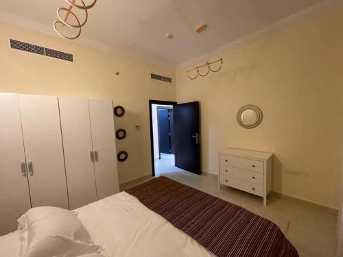 - une chambre avec un lit, une commode et un miroir dans l'établissement Lovely 1 Bedroom near to beach, à Charjah