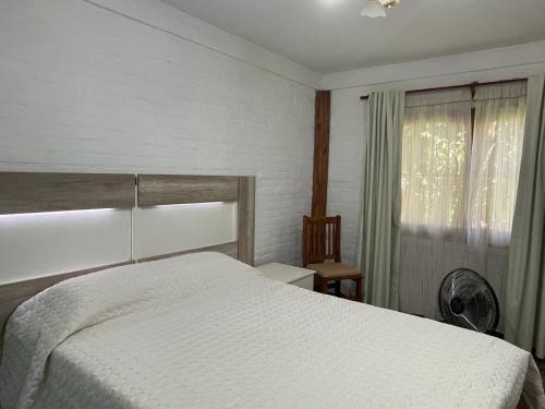 1 dormitorio con cama blanca y ventana en Paz Cerca de Termas Grandes en Gualeguaychú